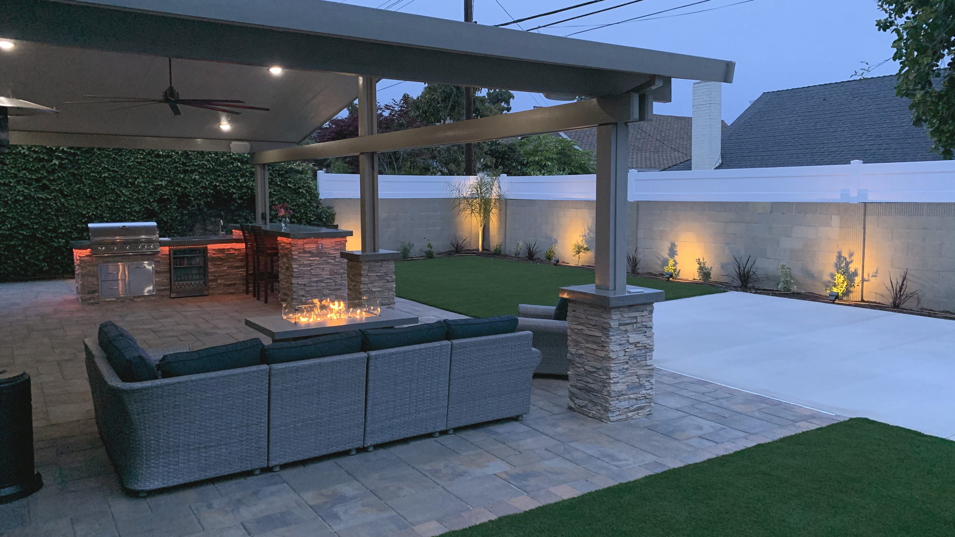 Dusk outdoor kitchen with fire and turf, Orange County